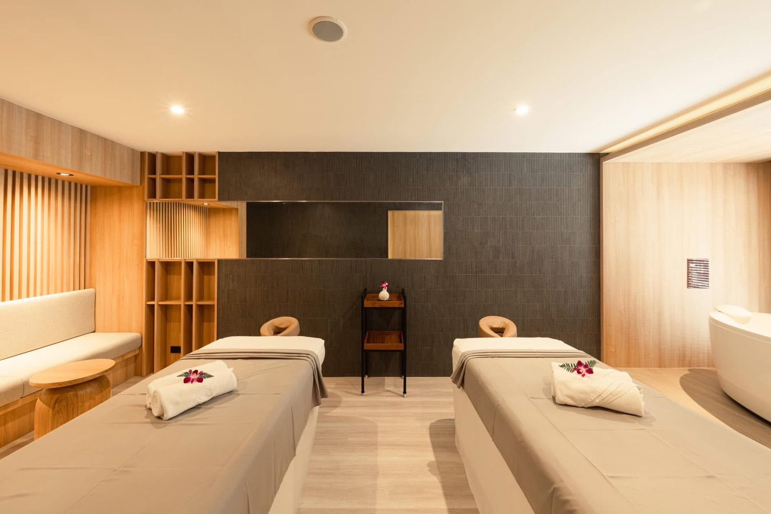 Luxurious Chiang Mai spa room featuring two massage beds, elegant wooden accents, and a relaxing ambiance perfect for pampering at Makkha Health & Spa.