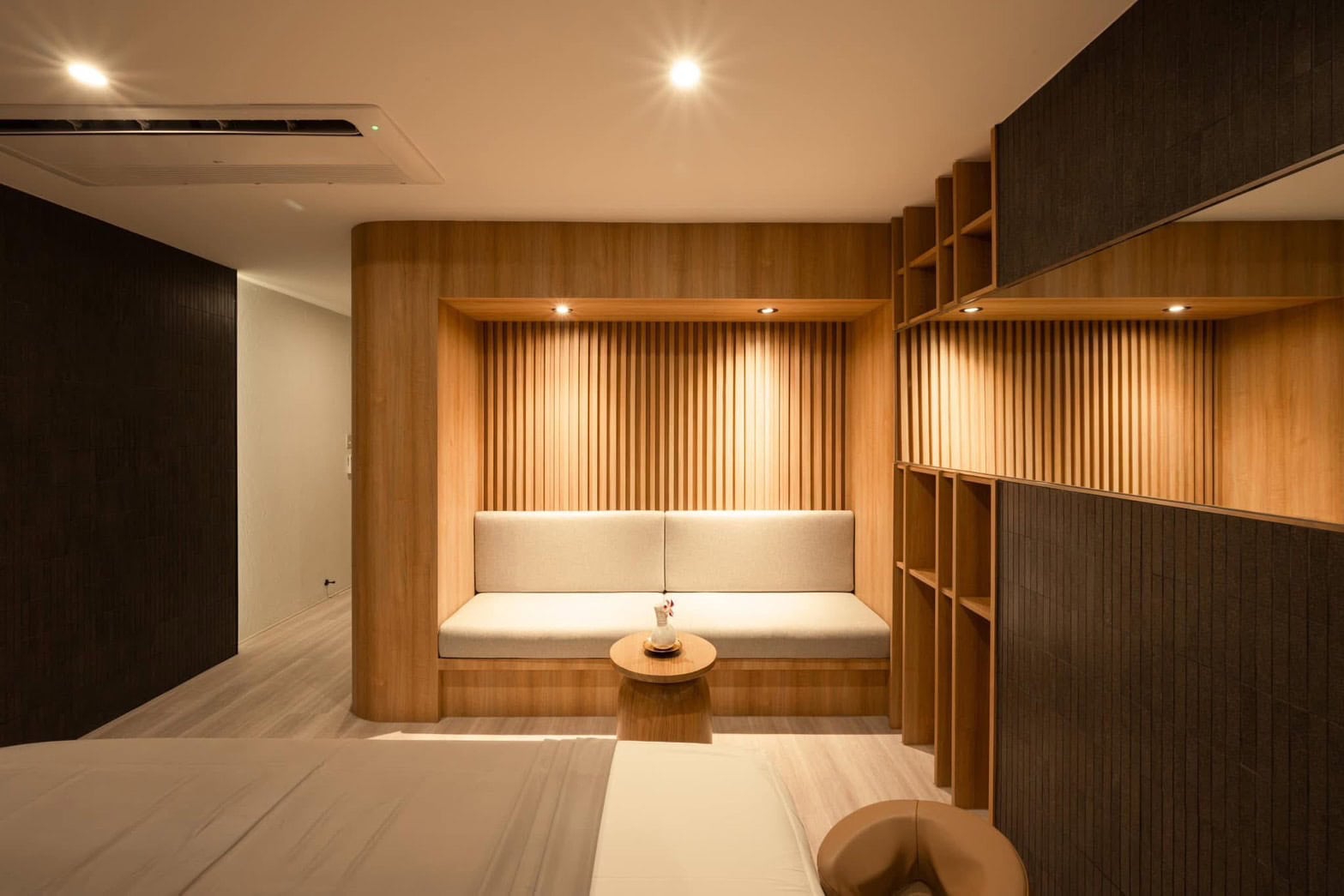 Elegant spa lounge with warm wooden accents and cozy seating for relaxation at Makkha Health & Spa in Chiang Mai.