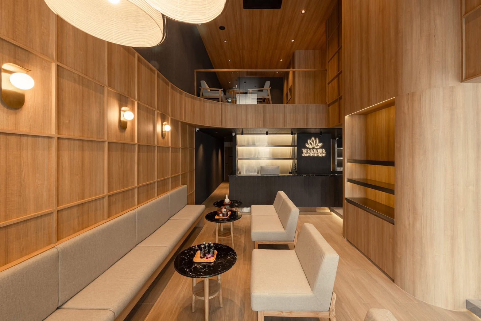 Serene wooden interior of Makkha Spa in Chiang Mai, featuring a modern reception area with warm lighting and elegant seating for a relaxing spa experience.
