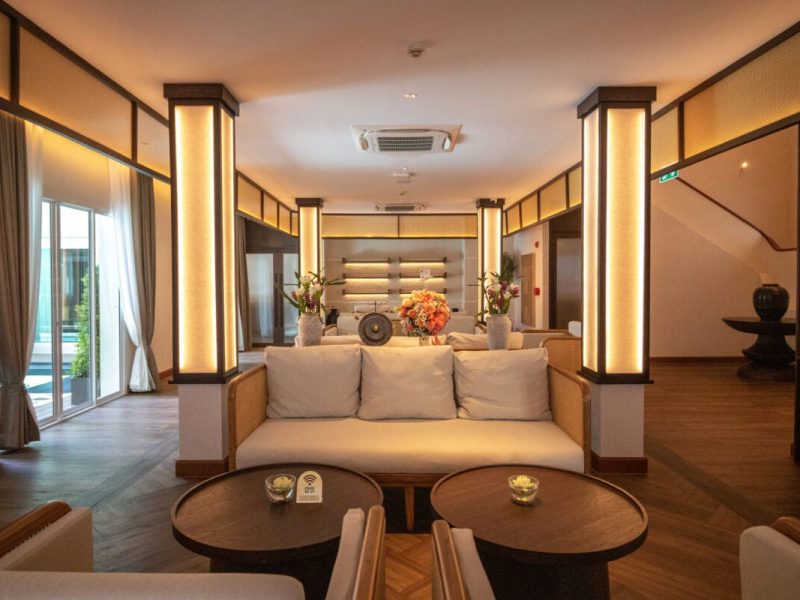 Elegant spa lounge interior with warm lighting, plush seating, and decorative flowers at Makkha Spa in Chiang Mai, offering top wellness treatments for relaxation.