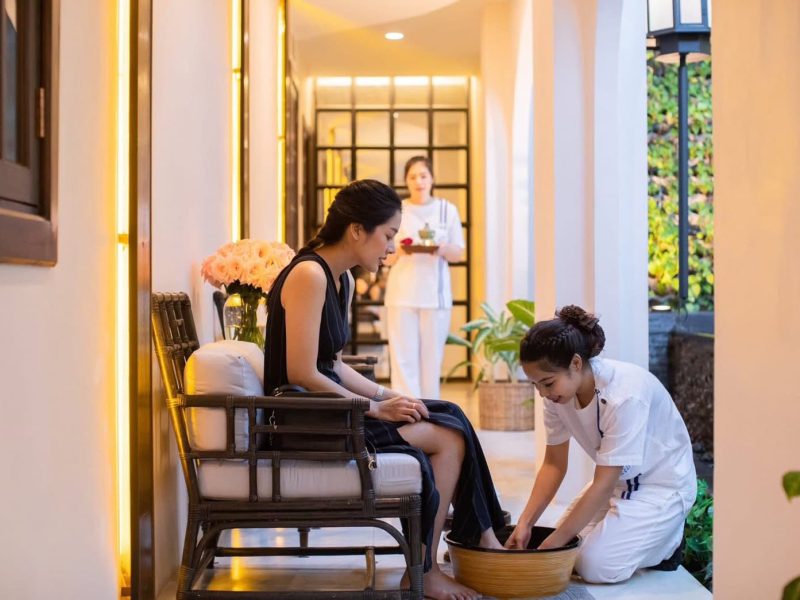 Relaxing Thai foot massage at Makkha Health & Spa in Chiang Mai, featuring a woman receiving foot treatment by a professional therapist in a tranquil, modern spa environment.