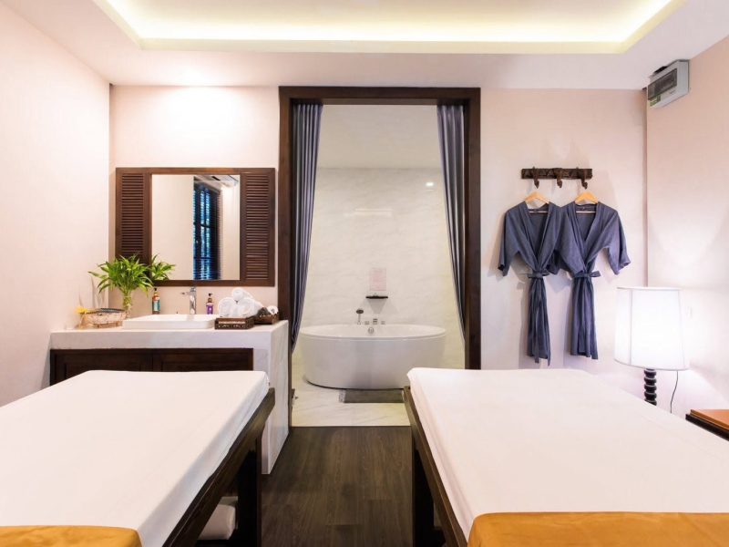 Luxurious spa room with two massage beds, a private bathtub area, and relaxing bathrobes, creating a serene atmosphere for ultimate relaxation at Makkha Health & Spa in Chiang Mai.