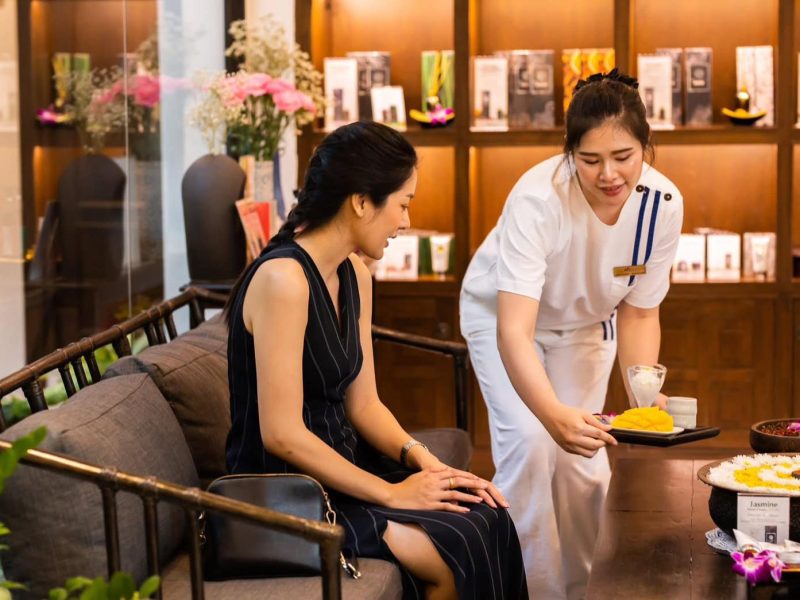 Luxurious spa treatment at Makkha Health & Spa Chiang Mai with an attentive therapist preparing a relaxing herbal therapy for a guest. Enjoy authentic Thai massage experiences in a serene setting.