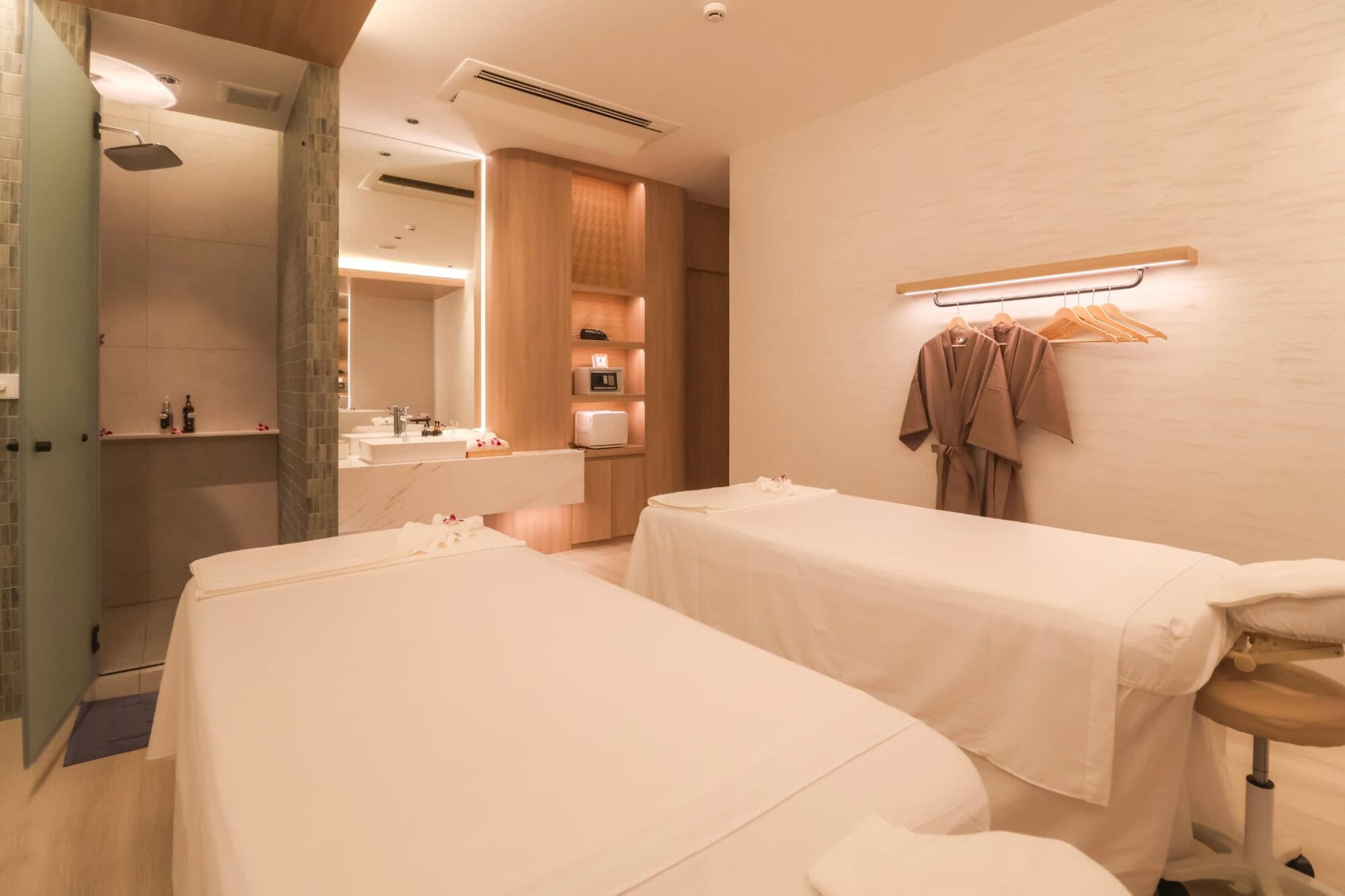 Relaxing spa treatment room at Makkha Health and Spa in Chiang Mai, featuring two massage beds, contemporary decor, soothing lighting, and a comfortable ambiance for ultimate relaxation.