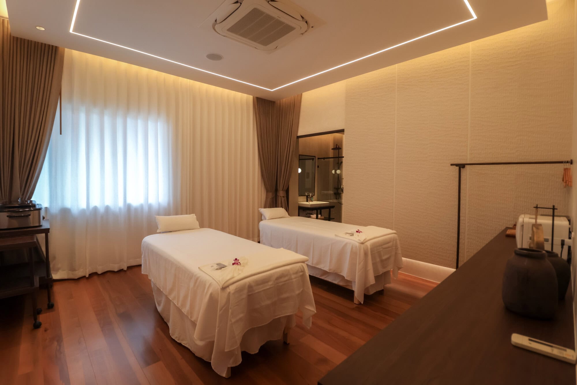 Relaxing massage room at Makkha Spa in Chiang Mai featuring two massage beds, warm ambient lighting, and modern decor for a luxurious spa experience.
