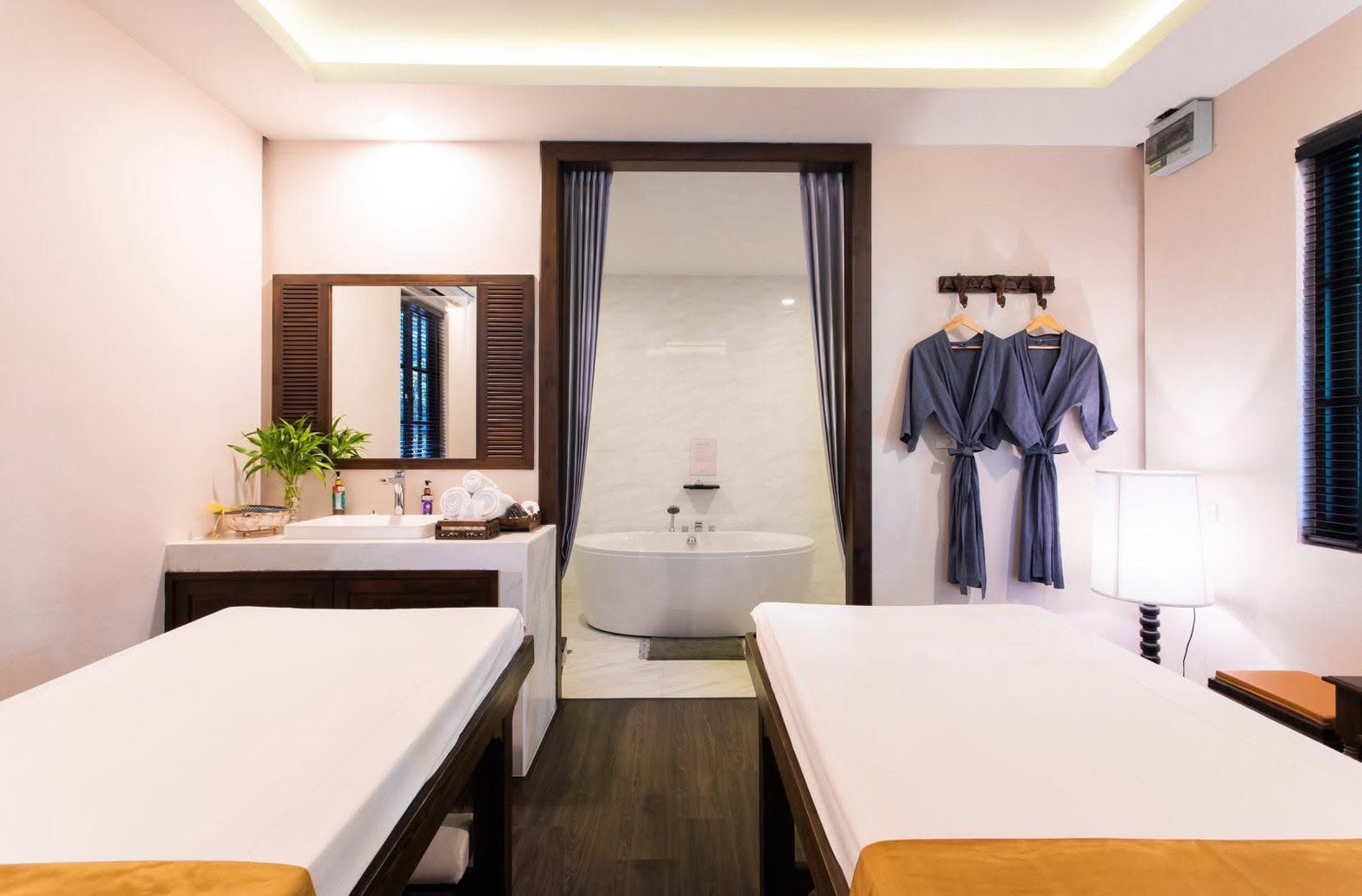 Luxurious spa room with two massage beds, a private bathtub area, and relaxing bathrobes, creating a serene atmosphere for ultimate relaxation at Makkha Health & Spa in Chiang Mai.