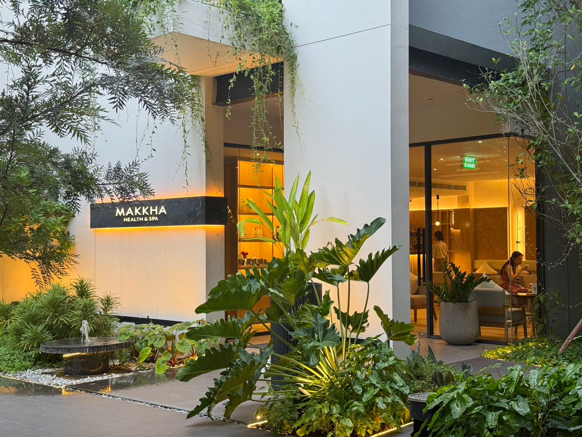 Luxury modern spa entrance with lush greenery and warm lighting at Makkha Health and Spa in Chiangmai.